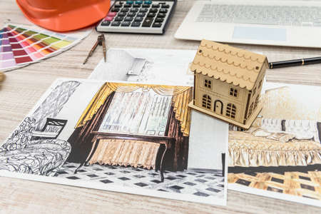 Top view of architects drawing modern house with sample material, hardhat, laptop on creative tableの写真素材