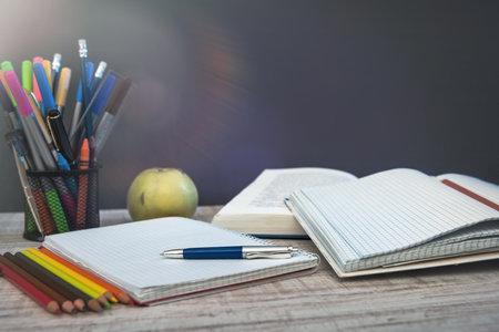 empty notepad on teacher desk against chalkboard. education concept.の写真素材