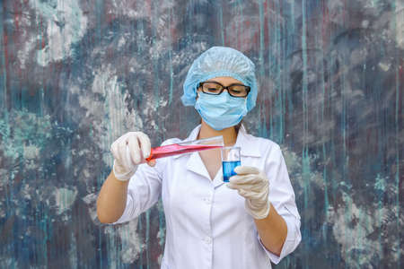 Woman chemist pouring substance from one test tube to another, making experimentの写真素材