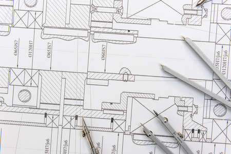 Paper with technical drawings and work tool on table. place of work