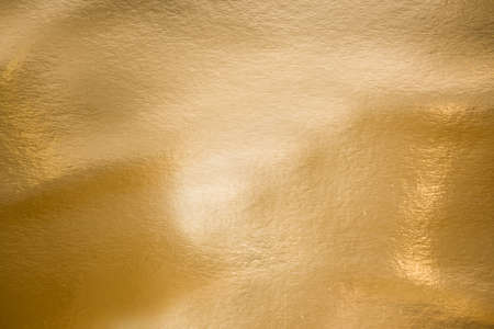 Gold texture as background. Paint leaks and ombre effects. Gold metallic foilの写真素材