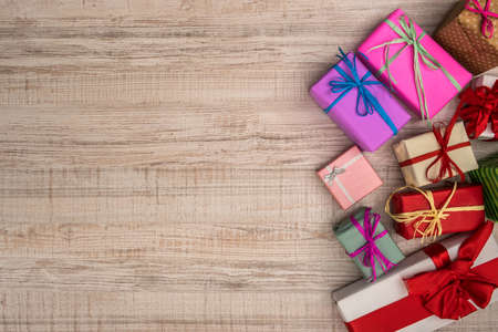 Colorful gift boxes on wooden table top view. Presents, new year and Christmas celebrationの写真素材
