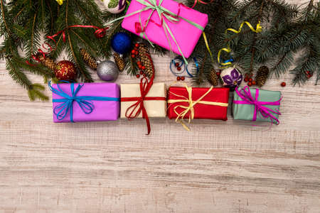 Christmas presents concept. Fir branches with cones and colorful gift boxes on table