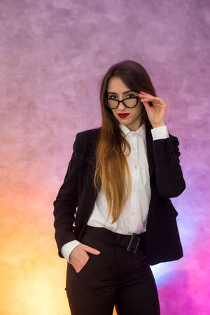 Attractive business woman gesturing ob abstract background in original spectaclesの写真素材