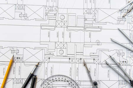 Paper with technical drawings and work tool on table. place of work