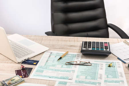 Accountant office - 1040 US tax forms April 15 of the deadline time, laptop, money and penの写真素材