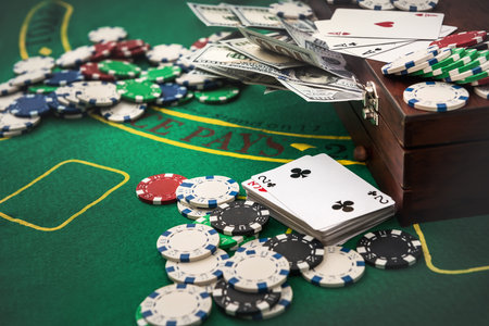 Suitcase with dollars, playing card, poker chips on the green poker table.の写真素材