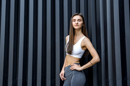 Sportive and very slim woman posing outdoors on abstract backgroundの写真素材
