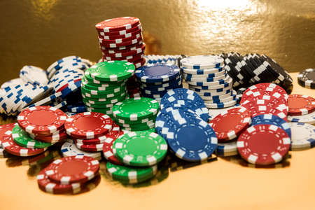 Stacks of poker chips isolated on golden background. Casino
