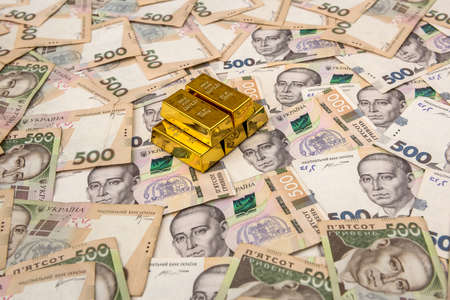 stacks of gold bars on ukraine moneu uah. top view.の写真素材