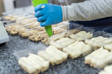 Industrial production of food. Confectioner making delicious desserts on factory.