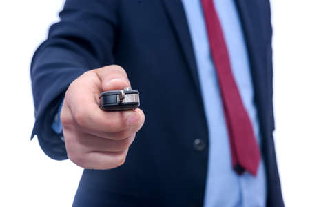 Man in suit holding car keys isolated on whiteの写真素材