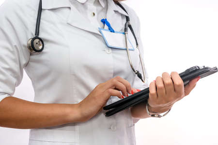 Doctor with clipboard. Pretty woman in medical uniform holding clipboard isolated on whiteの写真素材
