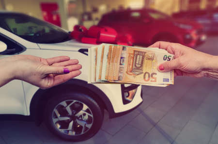 The buyer gives the seller a euro to enter into a contract to buy or lease a car.の写真素材