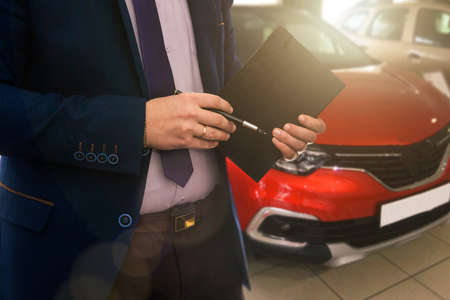 the manager accepts the order for the sale of a new car at the showroom.の写真素材