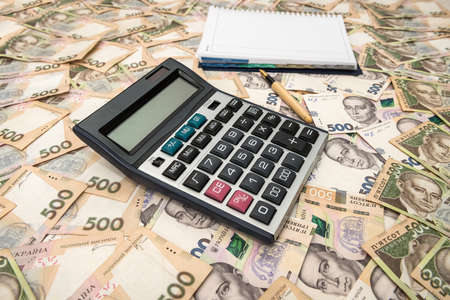 Empty notepad with calculator on Ukrainian Money backgrounds. 500 banknotes. Hryvnia (UAH). Top view.の写真素材