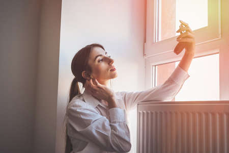 girl doing itself makeup near window in the background before taking a photossesionの写真素材