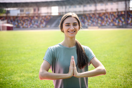 Morning exercises on stadium. Young, sporty and slim woman making exercises