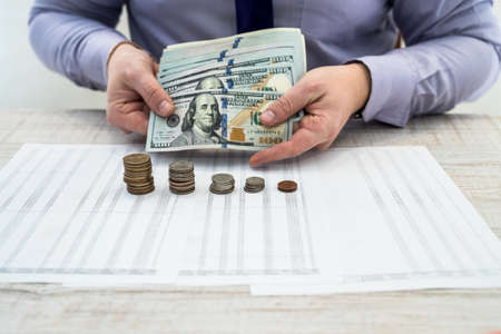 Office businessman working and analyzing company profits using charts and documents using coins....
