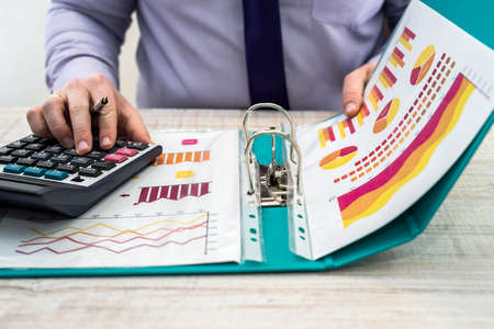 A business male analyzes revenue and graphs at office. Business analysis and strategy concept....