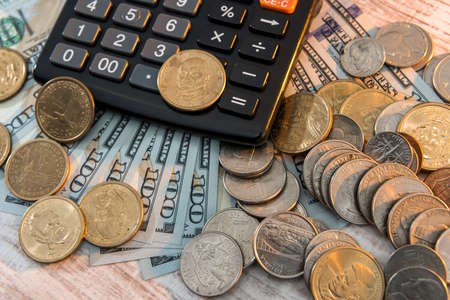 1 dollar us coin with calculator lying on dollar bills background. Money conceptの写真素材