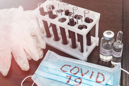 2019 new danger disease coronavirus (2019-nCoV). Fasical mask with blood test tube. Find virus vaccine concept.の写真素材