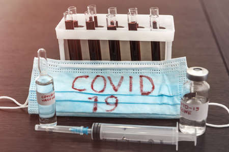 2019 new danger disease coronavirus (2019-nCoV). Fasical mask with blood test tube. Find virus vaccine concept.の写真素材