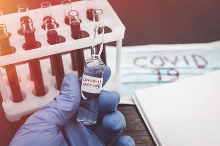 2019 new danger disease coronavirus (2019-nCoV). Fasical mask with blood test tube. Find virus vaccine concept.の写真素材