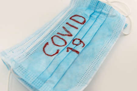 Medical disposable face mask with text covid-19. Coronavirus who causes pneumonia. Worldwide quarantine. diseaseの写真素材