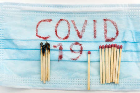 medicine concept covid 19 write on medical mask with matches bacteria 2019-ncov on white background. Coronavirus as danger disease. Ncov chinaの写真素材