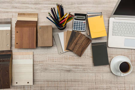 designer's workspace with some wooden color swatches, empty notepad, laptop and penの写真素材