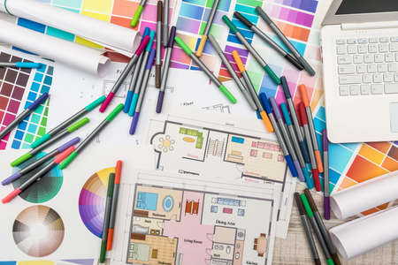Top view of architectural blueprints with material sample on creative desk.