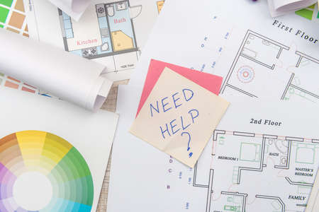 Top view of architectural blueprints with material sample on creative desk.の写真素材