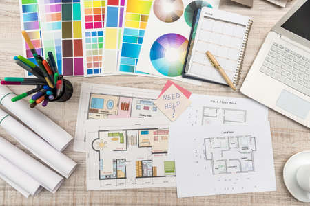 Designer's workplace top view. House plan with colorful palettes, laptop and cup of coffeeの写真素材