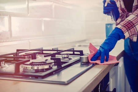woman doing kitchen cleaning chores with rubber gloves and rag. cleaning conceptの写真素材