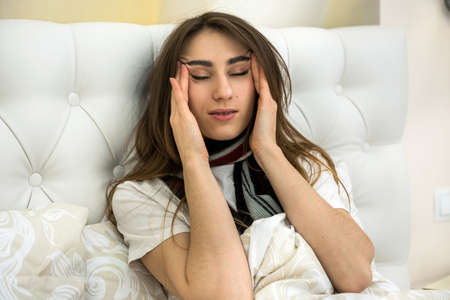 sick attractive girl lying in bed with taking a medicine.
