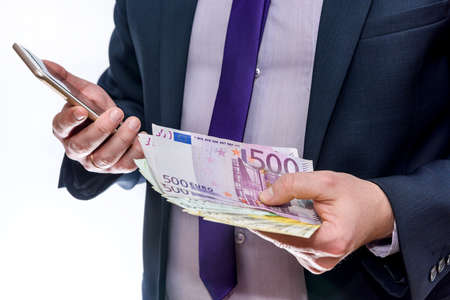 Businessman holds in one hand euro and another phone