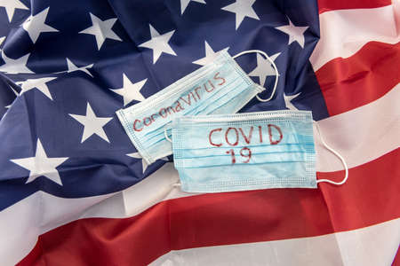 covid 19 outbreak worldwide. protective mask with text coronavirus on flag of usa. epidemicの写真素材