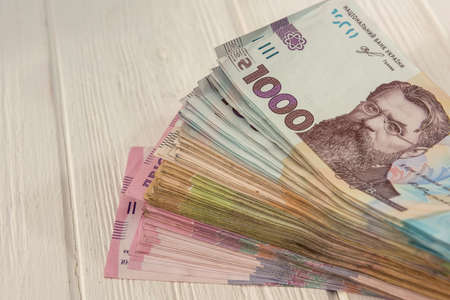 different ukraine money 1000 and 500 bills lying on wooden desk. UAH. Save and money conceptの写真素材