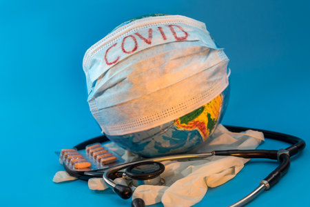 2019-nCoV earth globe with stethoscope and mask, virus concept. Coronavirus as text on surgical mask protection and oxygen face mask.の写真素材