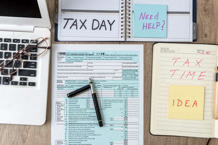 1040 USA individual tax form with laptop computer notepad, pen, sticker on a table, office...