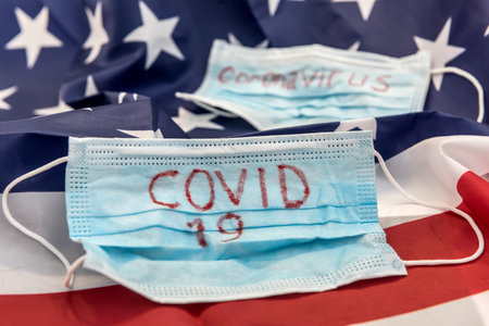 covid 19 outbreak worldwide. protective mask with text coronavirus on flag of usa. epidemicの写真素材