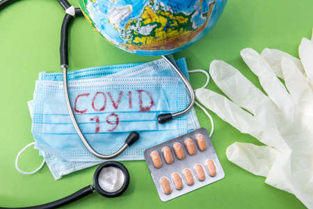 Covid-19 Global pandemic of the corona virus. Globe in a medical mask with gloves and stethoscope....