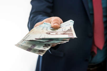businessman gives a bribe or pay, in isolation. UAH. 1000 new banknote Ukrainian moneyの写真素材
