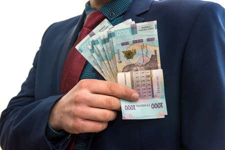A man in a suit with a huge pile of Ukrainian money. 1000 hryvnia. UAH.の写真素材