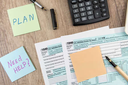 Sticker with text Need help calculator and 1040 tax form ondesk at office. Tax conceptの写真素材