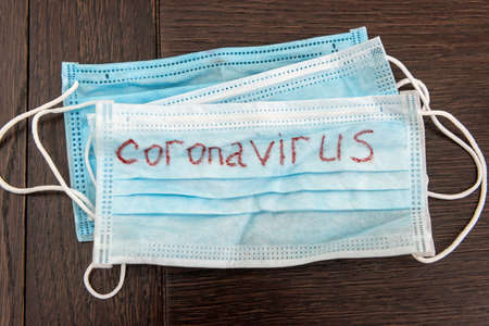 Medical disposable face mask with text covid-19. Coronavirus who causes pneumonia. Worldwide quarantine. diseaseの写真素材