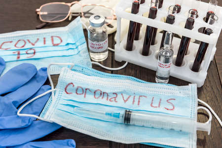 2019 new danger disease coronavirus (2019-nCoV). Fasical mask with blood test tube. Find virus vaccine concept.の写真素材