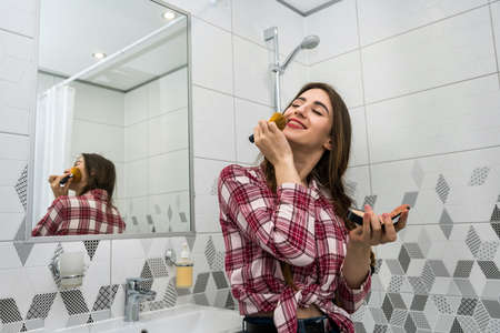 beautiful girl in the bathroom applies cream on her face. beauty concept.の写真素材