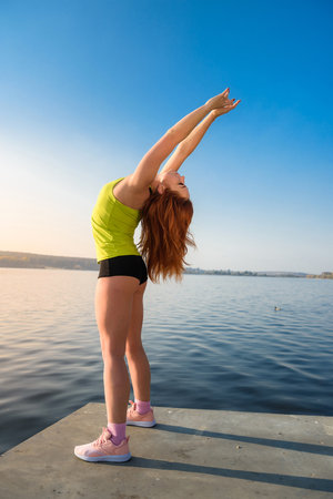 beautiful girl relaxing after morning gymnastics by the lake. health and beauty concept